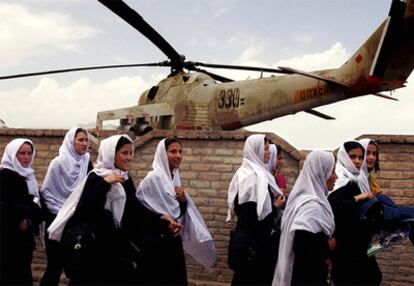 Un grupo de estudiantes pasa por delante de un helicóptero soviético de combate en 2004.