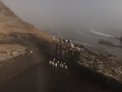 Un grupo de trabajadores en playa Cavero, en el distrito de Ventanilla, al norte de Lima, durante los primeros días del derrame. El Gobierno ha precisado que al menos 11.900 barriles de crudo (casi dos millones de litros de petróleo) fueron vertidos por Repsol frente a la costa peruana.