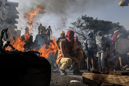 Decenas de manifestantes cierran una vía con una barricada en llamas durante una protesta antigubernamental, en Caracas, el 26 de junio de 2017.