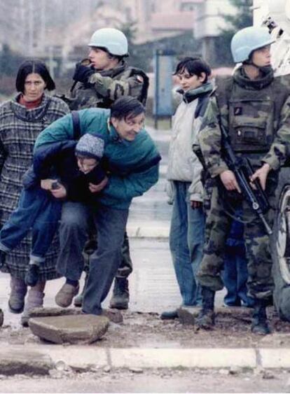 <b><i>Cascos azules</b></i> franceses en Sarajevo cubren del fuego de los francotiradores a un padre con su hijo en brazos, en marzo de 1995.