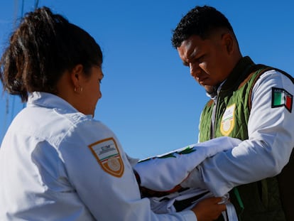 Agentes migratorios sostienen una bandera durante el funeral de Luis Alberto Olivas Garcia en Ciudad Juárez el 2 de enero 2024.