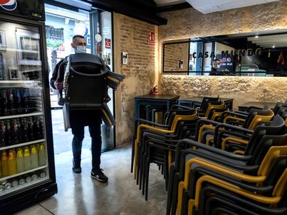 El propietario de un bar de Valencia recoge las sillas de la terraza el 18 de enero.