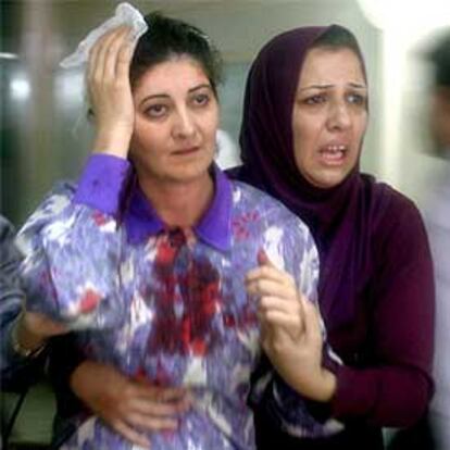 Una mujer ayuda a una herida en el atentado contra la sede de la Cruz Roja en Bagdad.