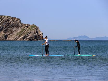 Aketza Sánchez e Idoia Fuertes recorren en pádel-surf las playas de Gorliz (Bizkaia) en busca de microplásticos.