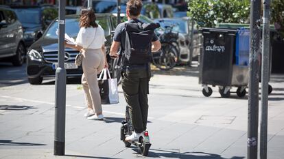 Un usuario de patinete eléctrico circula por la acera.