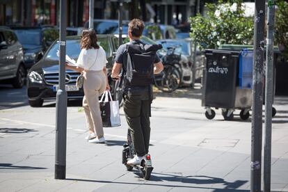 Un usuario de patinete eléctrico circula por la acera.