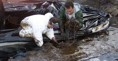 Percebeiros de Santa Mari&ntilde;a (A Coru&ntilde;a) recogen con las manos desde una barca el chapapote vertido por el petrolero en la zona de Pelouro.