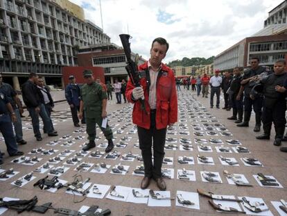 El ministro del Interior venezolano, Tareck El Aissami, sostiene un rifle durante una confiscaci&oacute;n de armas ilegales en 2009. 