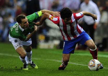 Arda Turan con el jugador Hannover 96 Steven Cherundolo.