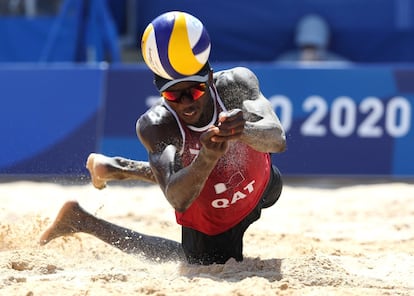 Ahmed Tijan, de Qatar, se lanza para golpear la bola durante el partido de vóley playa masculino.