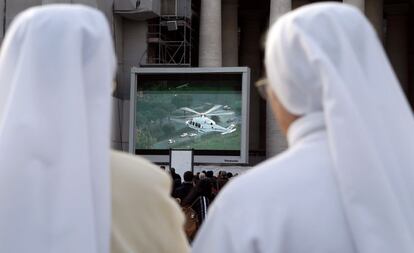 Unas monjas siguen por una pantalla de televisión, en la ciudad del Vaticano, la marcha del helicóptero que lleva al papa Benedicto XVI a la residencia papal de verano en Castel Gandolfo.