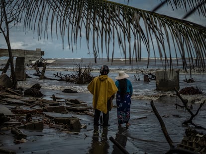 Dos habitantes de la colonia El Bosque, en Tabasco, ven los restos de su casa que fue destruída por una subida en el nivel del mar, en noviembre de 2022.