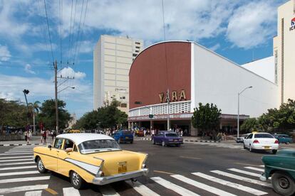 Un Chevrolet de 1957 pasa por la mítica esquina de las calles L y 23, donde se sitúa el cine Yara, en el barrio del Vedado.