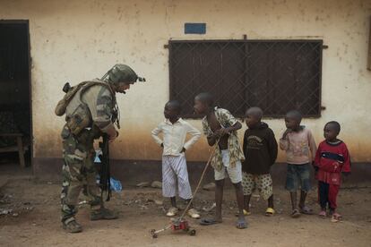 Un soldado francés habla a unos niños en un control de carretera en el barrio Miskine en Bangui, República Centroafricana.