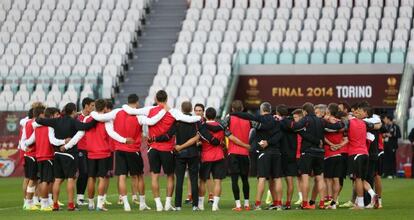 Los jugadores del Sevilla, abrazados en el entrenamiento.