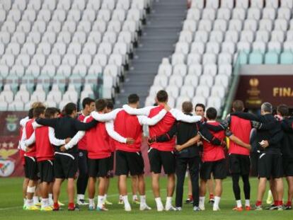 Los jugadores del Sevilla, abrazados en el entrenamiento.