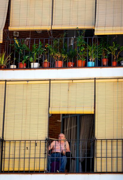Un vecino observa el devenir del barrio desde su balcón.