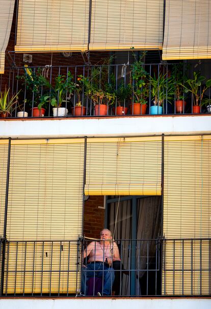 Un vecino observa el devenir del barrio desde su balcón. 