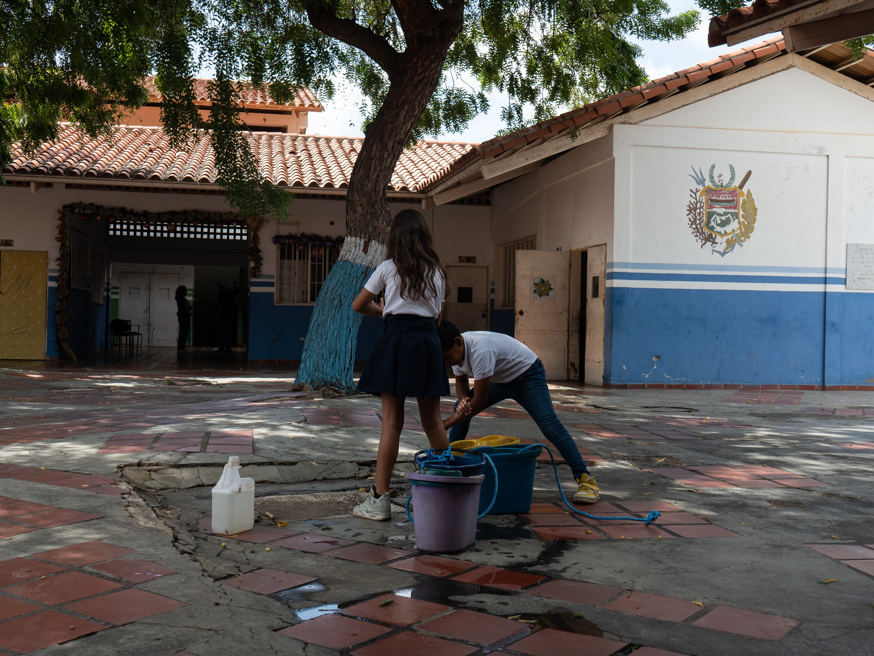 Dos niños se lavan las manos con el agua que sacan del pozo profundo en el colegio Rafael Salazar Brito de Margarita.