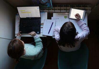 Dos niñas hacen los deberes del colegio en su casa, durante la pandemia de covid-19.