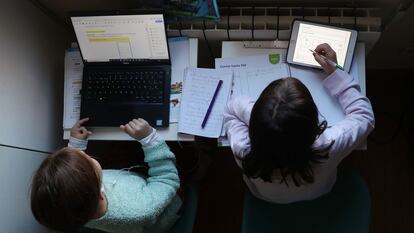 Dos niñas hacen los deberes del colegio en su casa, durante la pandemia de covid-19.