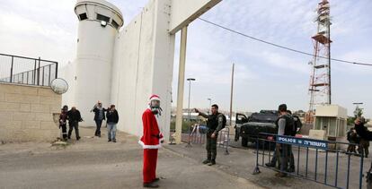 Un manifestante disfrazado de Papá Noel, ante el muro de separación en Belén.