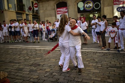 Una joven baila con un hombre de avanzada edad, en una calle de Pamplona. 