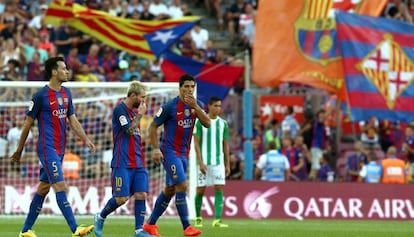 Busquets, Messi y Suárez, con la grada de animación de fondo.