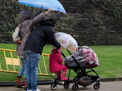 Una familia camina por La Ronda de la Muralla en Lugo, este sábado.