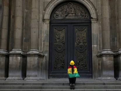 Uma mulher reza afora da Catedral de La Paz, depois do anúncio do presidente, Evo Morais, por sua renúncia, em La Paz (Bolívia) 10 de novembro.