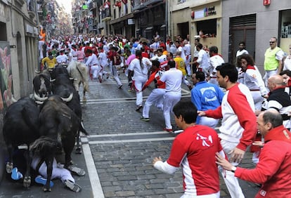 Vista de la calle Estafeta al paso de la manada de la ganadería de Dolores Aguirre. Los toros pasan por encima de dos corredores.