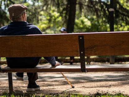 Un hombre mayor sentado en un banco del parque Caramuel, en el barrio de Puerta del Angel, Madrid.