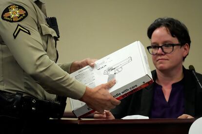 An assistant hands a box of evidence to expert Marissa Poppell.