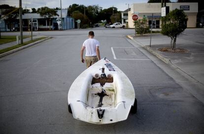 Emmett West saca su bote de un puerto deportivo cercano para asegurarlo en su casa frente al huracán Florence en Morehead City, Carolina del Norte.