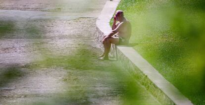 Un hombre toma el sol en la piscina pública de Oira, en Ourense. 