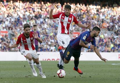 Luis Suárez (derecha) cae al suelo durante una jugada con Mikel San José (centro) y Yeray Álvarez.