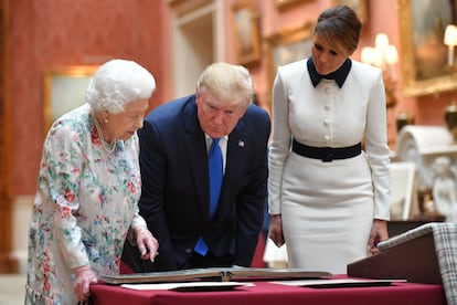 El presidente de los Estados Unidos, Donald Trump, y la primera dama, Melania Trump, observan piezas de la colección real junto a Isabel II en el palacio de Buckingham.