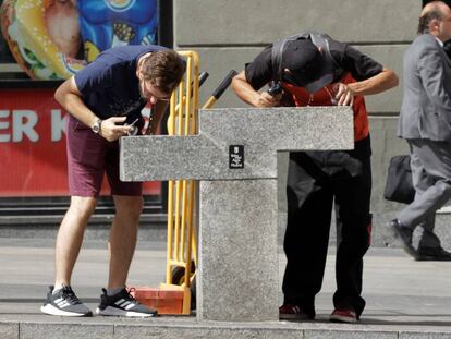 Dos jóvenes se refrescan en una fuente de Madrid, que tiene aviso amarillo por altas temperaturas.