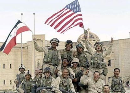 Los 'marines' ondean las banderas de Irak y EE UU frente al palacio de Sadam en Tikrit.