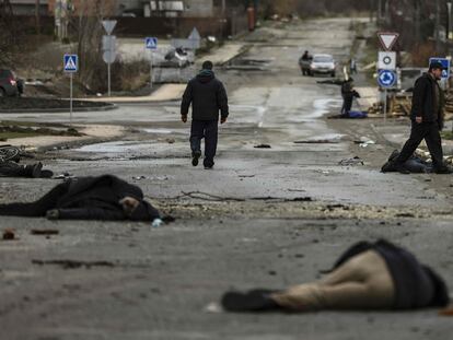 EDITORS NOTE: Graphic content / (FILES) In this file photo taken on April 02, 2022 bodies of civilian lie on Yablunska street in Bucha, northwest of Kyiv, after Russian army pull back from the city. - They all had different paths to death on Yablunska Street in Ukraine’s tragedy-scarred Bucha: A risky evacuation, a borrowed bicycle, a missing parent – one among them was even from Russia. But at the end of that path, at least 20 people in civilian clothes met what is widely alleged to be an overt violation of war crimes law by Russia’s invading forces. (Photo by RONALDO SCHEMIDT / AFP)