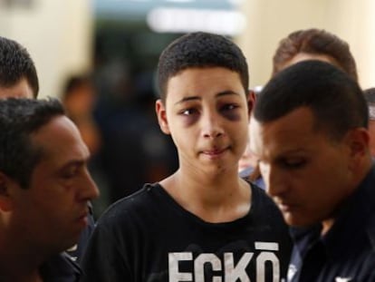 Tariq Jadair (centro), primo do jovem palestino assassinado, é levado ao tribunal de Jerusalém.