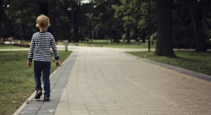 Un niño camina solo por la ciudad.