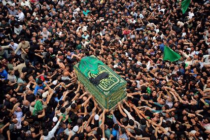 Devotos chiíes portan el féretro simbólico del séptimo imán de los chiíes, Musa al Kazem, durante una ceremonia para conmemorar su muerte en Bagdad (Irak).