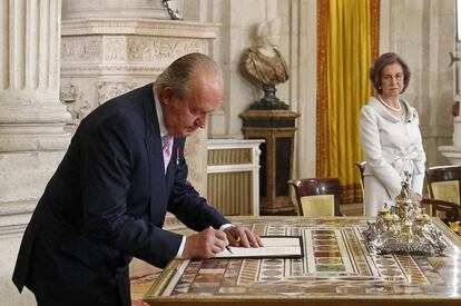 El Rey Juan Carlos, en presencia de la Reina Sofía, durante la firma.