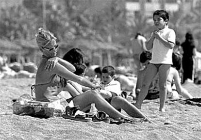 Una mujer y su hijo toman el sol en la céntrica playa de La Malagueta.