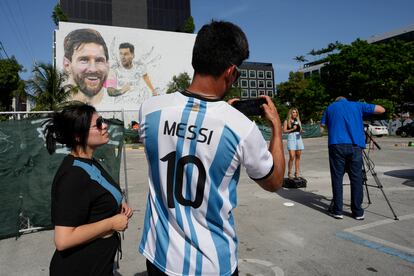 Un joven fotografía un mural realizado por el artista Maximiliano Bagnasco en el barrio de Wynwood. En la obra figuran dos retratos de Messi: uno de él sonriendo y otro del jugador durante un partido.  