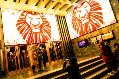 Varios turistas se hacen junto al cartel del musical El rey león en el teatro Calderón de Madrid, el 5 de diciembre.