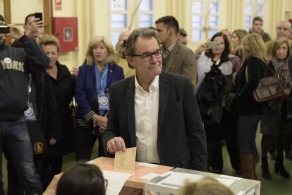 El president de la Generalitat en funcions, Artur Mas, votant envoltat de curiosos i periodistes.