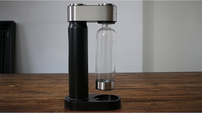 Máquina gasificadora de agua sobre una mesa de madera.