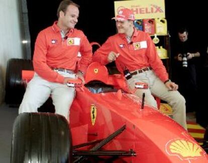 Michael Schumacher (dcha.) y Rubens Barrichello, sobre una réplica de un Ferrari.